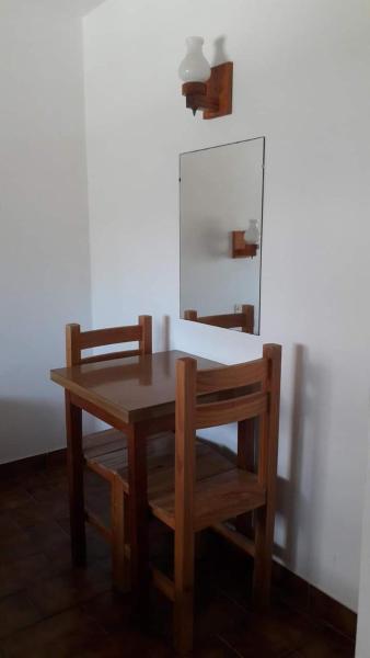 una mesa de madera con 2 sillas y un espejo en Grupo Idaho en Villa Gesell
