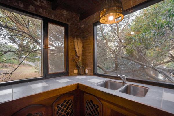 cocina con fregadero y 2 ventanas grandes en Kimba Bosque en Mar de las Pampas