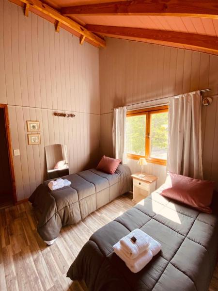 1 dormitorio con 2 camas y ventana en CASA ANDINA en San Martín de los Andes