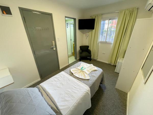 una habitación de hotel con una cama con una toalla en Aguila Blanca en Villa Gesell