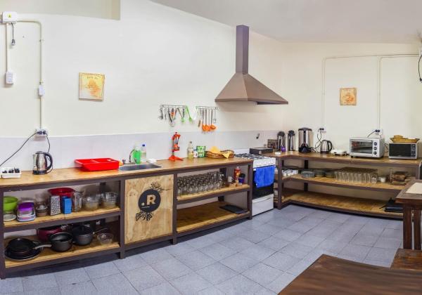 cocina grande con encimeras de madera y fogones en HOSTEL PUNTO RAMIREZ en Salta