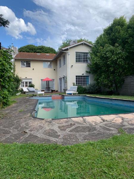 una casa con piscina frente a una casa en Casa grande con pileta zona B. los Troncos/Playa chica en Mar del Plata