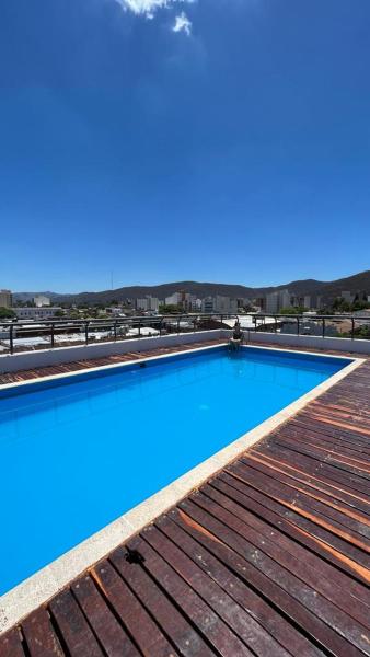 una piscina azul con terraza de madera en Alsina 728 con pileta UKIYO en Salta