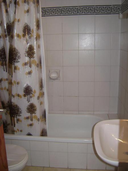 un baño con cortina de ducha con inodoro y aseo en El Ebro en Villa Gesell