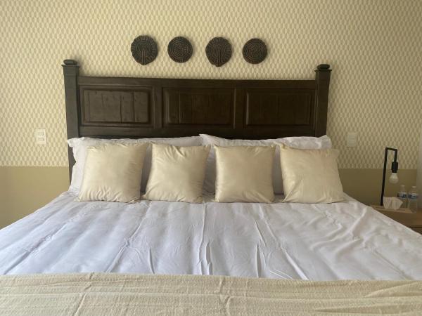 Una cama con sábanas blancas y almohadas en un dormitorio en ACOGEDOR DEPARTAMENTO en zona de Santa Fé, en Ciudad de México