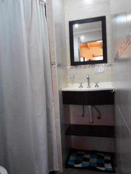 y baño con lavabo y espejo. en Cabañas Dulce Atardecer, en Villa Carlos Paz