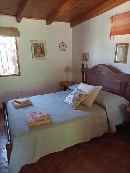 1 dormitorio con 1 cama con 2 toallas en Cabañas Farah Estancia Vieja ideal para 2, en Villa Carlos Paz