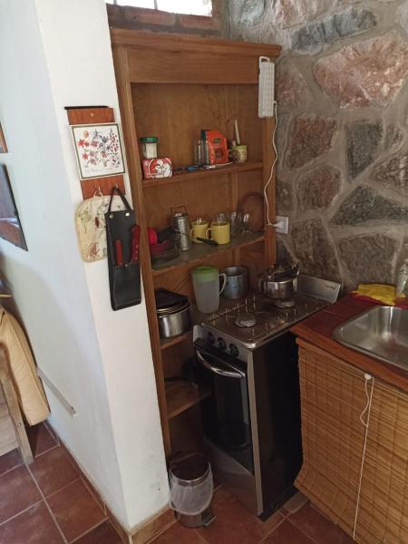 una pequeña cocina con fogones y fregadero en Cabañas Farah Estancia Vieja ideal para 2, en Villa Carlos Paz