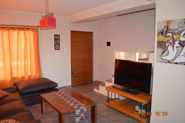 sala de estar con sofá y Tv LED en Cerro Negro, Complejo en Villa General Belgrano