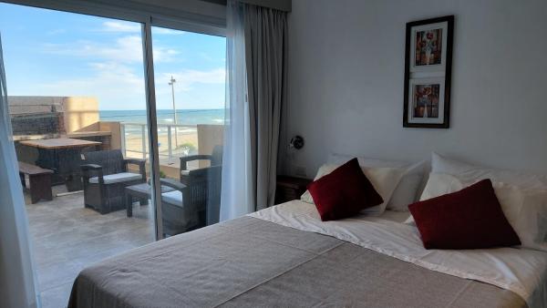 1 dormitorio con cama y vistas al océano en Los Tritones Apart Hotel en Villa Gesell
