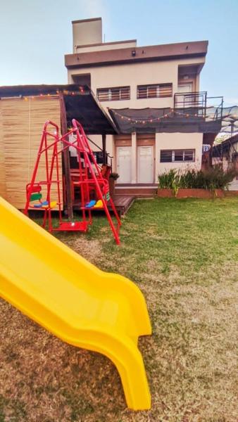 un parque infantil con un tobogán frente a una casa en Departamentos Bienestar Federacion, en Federación