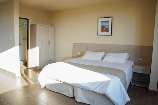 1 dormitorio con 1 cama blanca grande. en Solana - Apart Hotel & Club de Tenis en Santa Clara del Mar