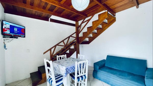 sala de estar con sofá azul y escalera en Residencial Morro do Macaco, en Bombinhas