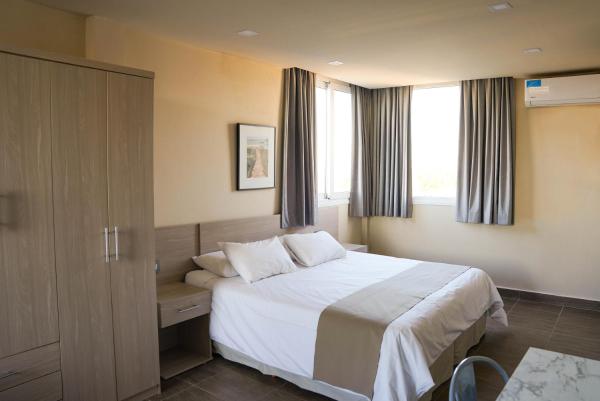 Habitación de hotel con cama y ventana en Solana - Apart Hotel & Club de Tenis en Santa Clara del Mar