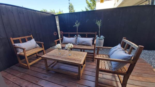 un patio con 2 sillas y una mesa con almohadas en Hermoso departamento 2 ambientes con amplio jardin en el centro de SMA. 6V5 en San Martín de los Andes