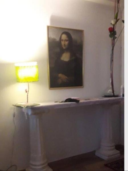 una mesa con una lámpara y una foto en una pared en CARICLAU STANZA TORRES GALERIA JARDIN MICROCENTRO en Buenos Aires
