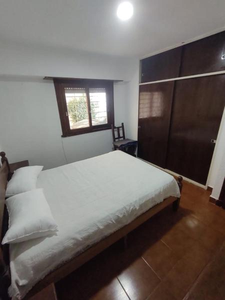 Un dormitorio con una gran cama blanca y una ventana en Departamento Parque Luro para 5 personas en Mar del Plata