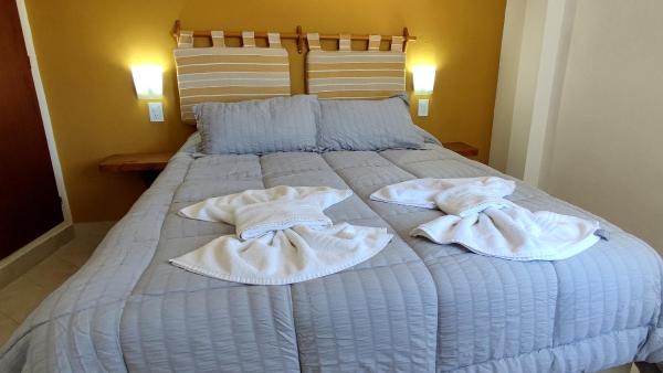una cama con dos toallas encima en Apart Octogono Condominio en Villa Gesell