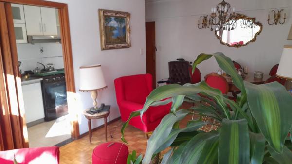 una sala de estar con sillas rojas y una planta en Departamento CENTRO Mar del Plata en Mar del Plata