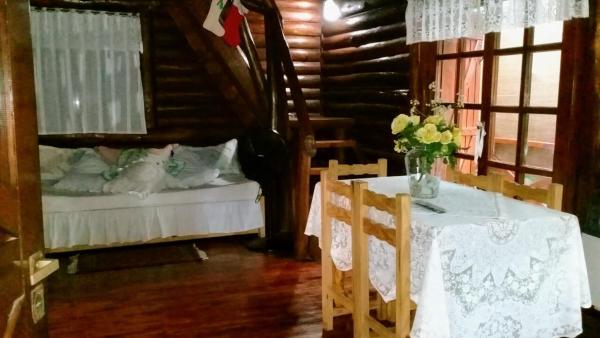 comedor con mesa y cama en Cabañas De La Abuela en Mar de las Pampas