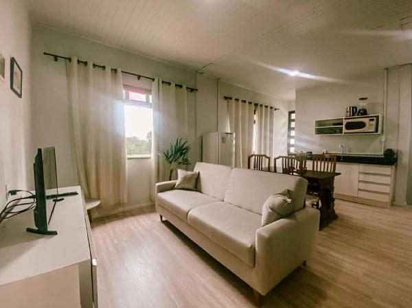 a living room with a couch and a table at Garden 437 - Suítes e Lofts in Florianópolis