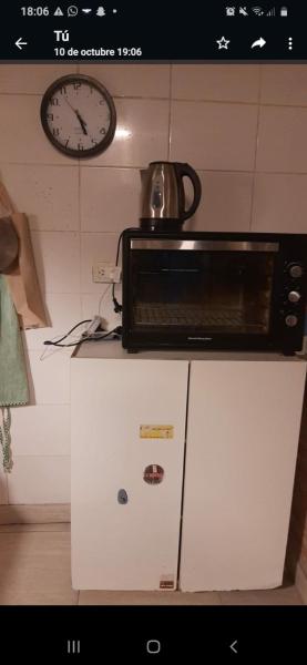 un microondas sobre una refrigerador en Hostal Summer Mayo MDP en Mar del Plata