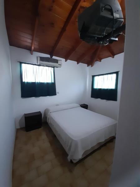 un dormitorio con cama y un televisor de pantalla plana en Tineo en Villa Gesell