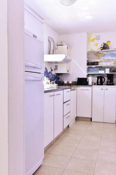 una cocina blanca con armarios blancos y electrodomésticos blancos en Adhara en Puerto Madryn