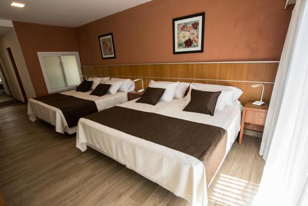 Habitación de hotel con 2 camas y espejo en HOTEL MIS SOLES en Villa Gesell