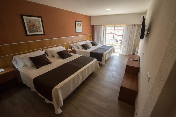 una habitación de hotel con dos camas y ventana en el HOTEL MIS SOLES de Villa Gesell