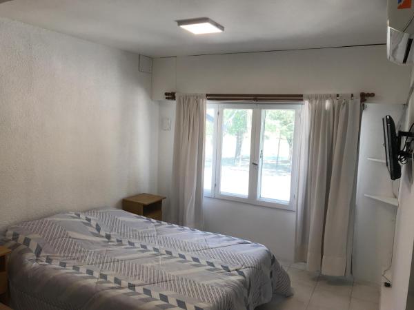 1 dormitorio con cama y ventana en el Departamento Jardín - 4 en Villa Gesell