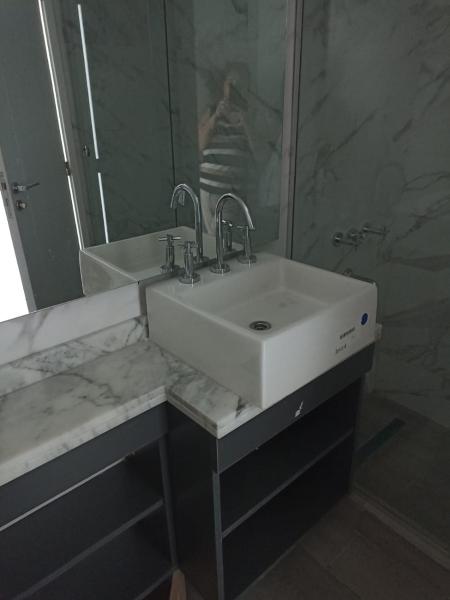 y baño con lavabo blanco y espejo. en Alquiler FIDUS en Mar del Plata