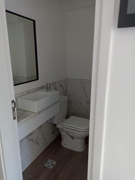 y baño con lavabo, aseo y espejo. en Alquiler FIDUS en Mar del Plata