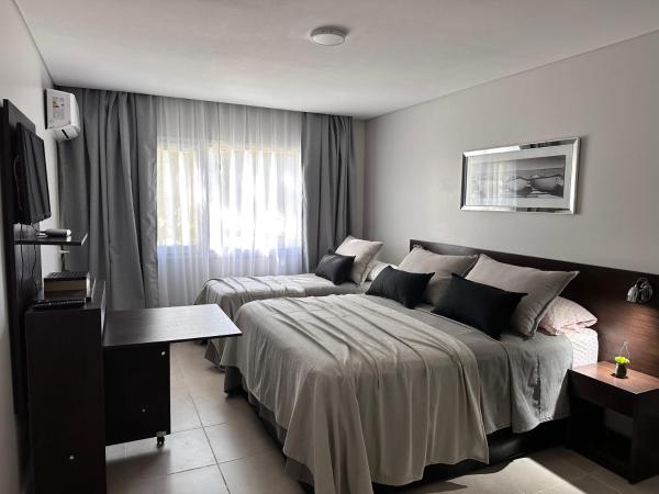 Habitación de hotel con cama y sofá en Suite del sol en Pinamar
