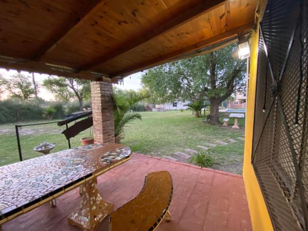 un patio con mesa y sillas en un porche en Los Tres Chiflados Chascomús en Chascomús