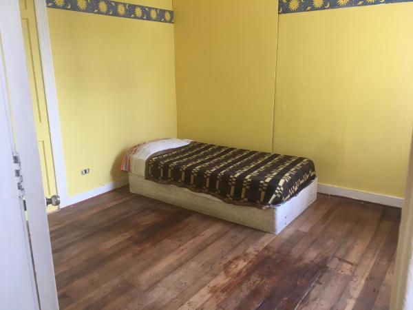 1 dormitorio con 1 cama en una habitación con suelo de madera en Casapuerto, en Valparaíso