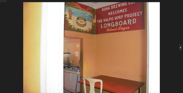 una cocina con una mesa y un cartel en la pared en Casapuerto, en Valparaíso