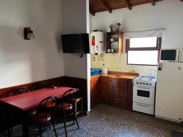 una pequeña cocina con mesa y heladera en PH a 1 cuadra de la playa, 2 con, patio y parrilla en Villa Gesell