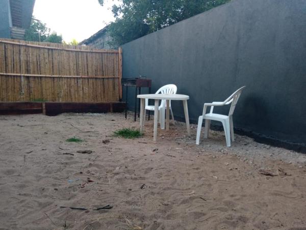 Dos sillas blancas y una mesa en el patio trasero. en Monoambiente completo con 2 patios y parrilla. en Ostende