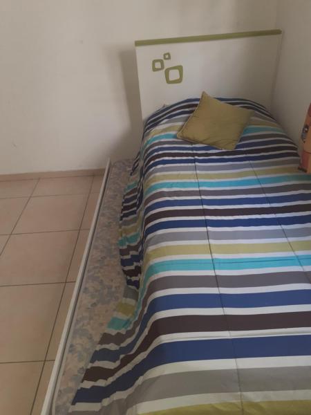 Una cama con una manta a rayas en una habitación en Excelente departamento en Mendoza en Mendoza