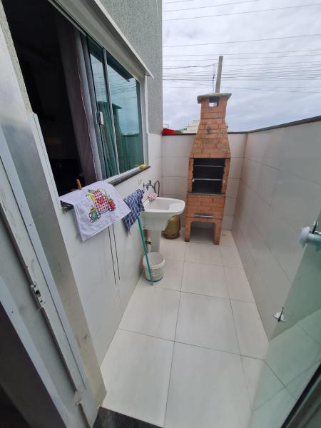 baño con lavabo y aseo y ventana en Siri Mariscal. Casa com Piscina, en Bombinhas