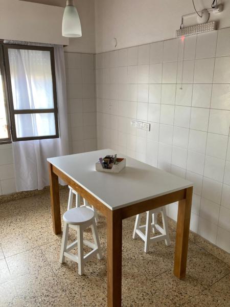 una mesa en una habitación con dos taburetes y una ventana en Madryn home Pto Madryn en Puerto Madryn