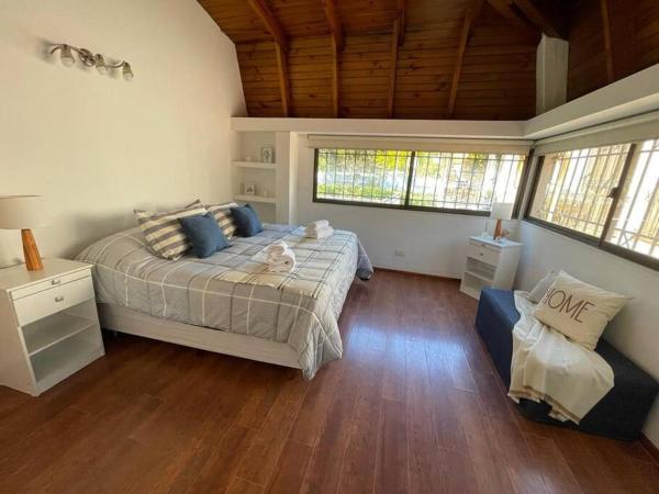 1 dormitorio con cama y sofá en Espectacular departamento cerca del parque en Mendoza
