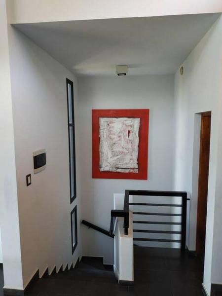 un pasillo con una escalera y una pintura en la pared en Casa en Villa Carlos Paz en Villa Carlos Paz