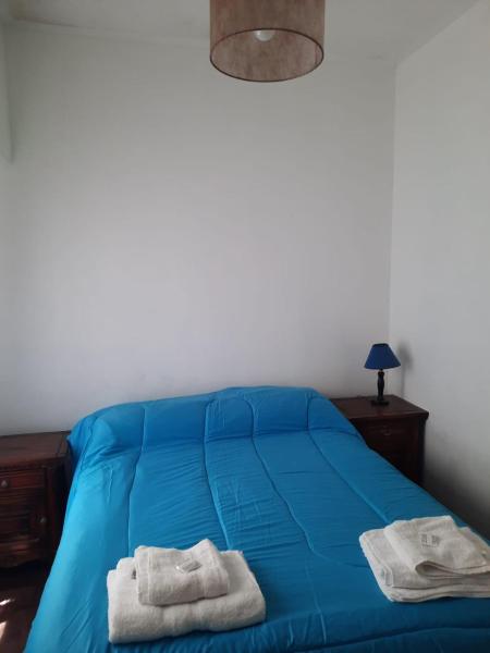 Un dormitorio con una cama azul con toallas. en Departamento Brown - zona centro en Mar del Plata