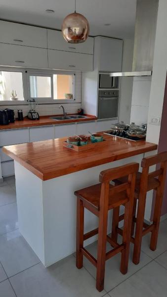 cocina con encimera de madera y 2 sillas en La Herradura en Pinamar