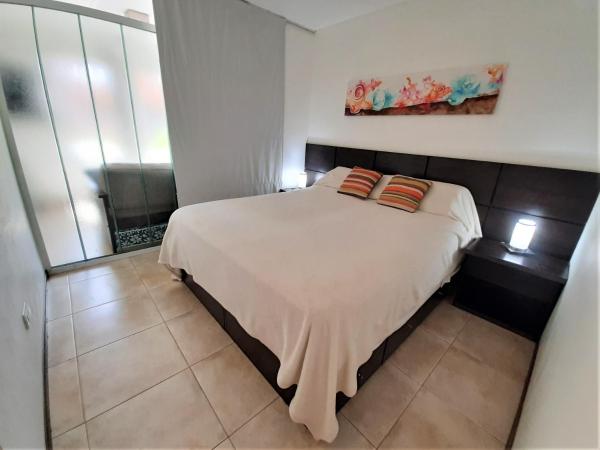 1 dormitorio con 1 cama blanca grande y 2 almohadas en Departamento Mariano Moreno en San Martín de los Andes