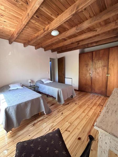 Habitación grande con 2 camas y suelo de madera. en Apartamento en Mendoza en Mendoza