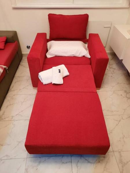 Un sofá rojo con dos almohadas blancas. en Departamento de Lujo en la Ciudad Buenos Aires en Buenos Aires