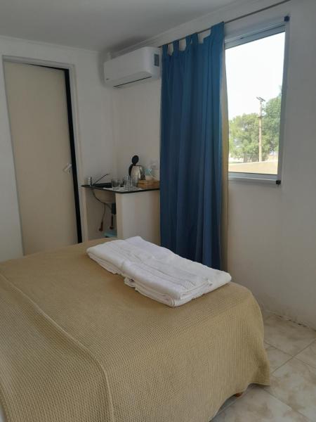 1 dormitorio con 1 cama con cortina azul y ventana en Matices en Gualeguaychú